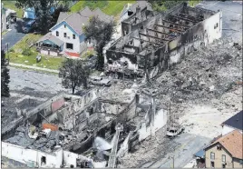  ?? John Hart ?? The Associated Press In a view looking northwest from above, the aftermath of a gas explosion is seen Wednesday in downtown Sun Prairie, Wis. At the top right of the image is the site of the former Barr House, where the explosion originated and leveled...