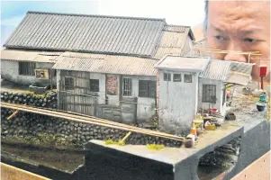  ??  ?? Miniature model artist Hank Cheng inspects one of his works in a showroom in Taipei.