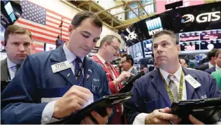  ?? — AP ?? NEW YORK: Traders Christophe­r LaGana (foreground left) and William McInerney (right), work on the floor of the New York Stock Exchange yesterday. The S&P 500 and the Nasdaq touched record highs for the second straight day yesterday following a spate of...