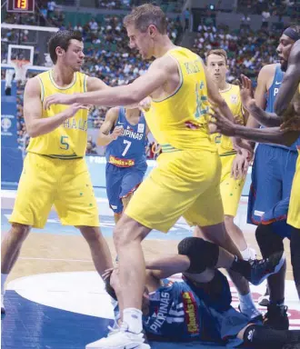  ?? JOEY MENDOZA ?? RR Pogoy lies sprawled on the floor after absorbing a hard blow from Daniel Kickert of Australia (foreground) sparking a free-for-all that marred the Gilas-Australia game for the FIBA World Cup qualifiers last night at the Philippine Arena.