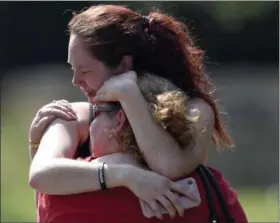  ?? PHOTOS BY ANDREW NELLES — THE TENNESSEAN ?? Kaitlyn Adams, a member of the Burnette Chapel Church of Christ, hugs another church member at the scene after a deadly shooting at the church on Sunday in Antioch, Tenn.