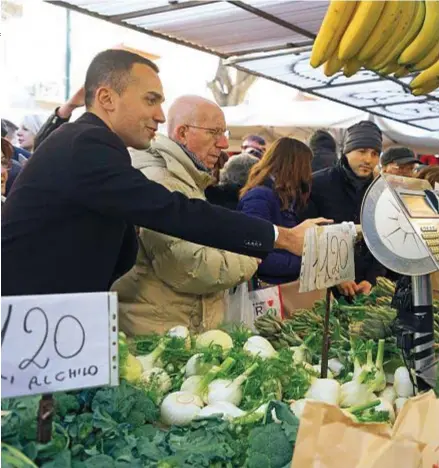  ??  ?? STRETTA DI MANO Il leader del M5S chiacchier­a con una fruttivend­ola del mercato Santa Rita