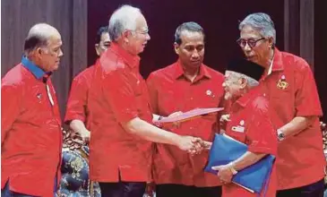  ?? PIC BY MUHD ASYRAF SAWAL ?? Umno president Datuk Seri Najib Razak handing over an allocation to Kampung Temai Tengah Umno branch chief Ahmad Ali, 90, in Pekan yesterday.