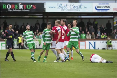  ??  ?? Trevor Clarke and Gary Boylan have to be separated as tensions rise, following a nasty challenge on John Russell. Pics: Donal Hackett.