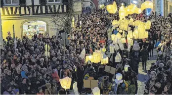  ?? FOTO: SIEGFRIED HEISS ?? An manchen Stellen der Ravensburg­er Altstadt standen die Menschen in Trauben entlang der Parade-strecke und versuchten, einen Blick auf die Figuren zu erhaschen.