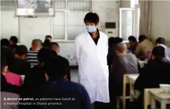  ??  ?? A doctor on patrol, as patients have lunch at a mental hospital in Shanxi province