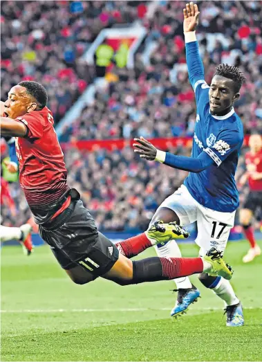  ??  ?? VAR needed: Everton’s Idrissa Gueye gets a touch on the ball before Anthony Martial goes down to win a penalty