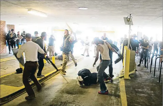  ?? ZACH D. ROBERTS / AP ?? Un grupo de racistas blancos apalean a DeAndre Harris, el pasado 12 de agosto, en un aparcamien­to de Charlottes­ville
