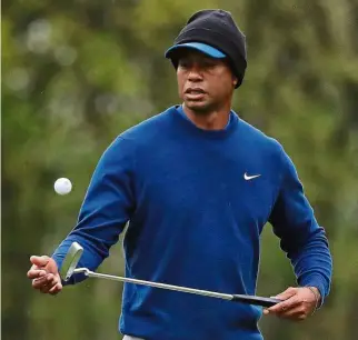  ??  ?? Calm before
the storm: Tiger Woods flipping the ball as he walks along the ninth green during the practice session of the PGA Championsh­ip on Monday. — AP