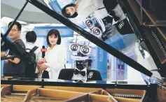  ??  ?? People watch the robot ‘Teo Tronico’, designed by Matteo Suzzi, play piano and sing popular songs at the 2017 World Robot Conference in Beijing, China. Researcher­s who warned half a dozen robot manufactur­ers in January about nearly 50 vulnerabil­ities...