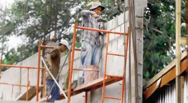  ?? ?? PROYECTOS. Albañiles trabajan en la construcci­ón de viviendas de clase media en San Pedro Sula.