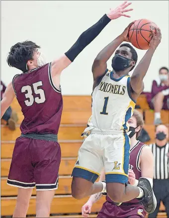  ?? SARAH GORDON/THE DAY ?? Ledyard’s James Green (1) rise to get his shot up against East Lyme’s Marshall Gada (35) during Tuesday night’s ECC South Division boys’ basketball game at Ledyard.