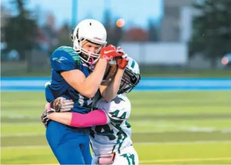  ?? PHOTO COURTESY OF TERRILL BODNER ?? TJ Nyberg of the Kelly Road Roadrunner­s makes the catch and gets wrapped up immediatel­y by Prince George Polars tackler Gavin Murray during Thursday’s battle for first place in the Northern Conference Tier 2 varsity division. The Polars won 35-14.