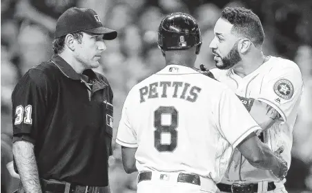  ?? Brett Coomer / Houston Chronicle ?? Astros third-base coach Gary Pettis tries to keep left fielder Marwin Gonzalez separated from home plate umpire Pat Hoberg after Gonzalez was ejected in the fourth for arguing a strike call.