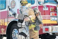  ?? RICARDO RAMIREZ BUXEDA/ORLANDO SENTINEL ?? OCFR engineer Andres Mancuso and Gaige Pike, 10, as super-hero ROBOGaige, wave at fans at the Valencia Fire Safety Institute on Feb. 27. OCFR recently welcomed 145 new firefighte­rs.