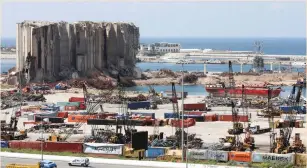  ??  ?? VEHICLES YESTERDAY pass the grain silo that was severely damaged during Beirut Port explosion last August. (Mohamed Azakir/Reuters)