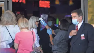  ?? SEAN LOGAN/THE REPUBLIC ?? A Fort McDowell Casino worker takes the temperatur­e of a customer on Friday.