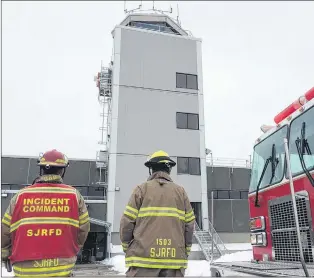  ?? JOE GIBBONS/THE TELEGRAM ?? St. John’s Regional Fire Department Lt. Jason Penney (left) and F/F Michael Furlong look up at the control tower at St. John’s Internatio­nal Airport Wednesday. A carbon monoxide leak led to the evacuation of the facility for about two hours. No one was...