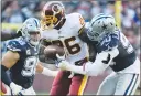  ?? Associated Press photo ?? Washington Redskins running back Adrian Peterson (26) runs between Dallas Cowboys defensive end Tyrone Crawford (98) and defensive end Demarcus Lawrence (90) during the first half of an NFL football game, Sunday in Landover, Md.