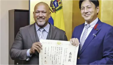  ?? The Yomiuri Shimbun ?? Alex Ramirez, left, smiles as he receives the Foreign Minister’s Commendati­on certificat­e from State Foreign Minister Shunsuke Takei at the Foreign Ministry on Oct. 13.