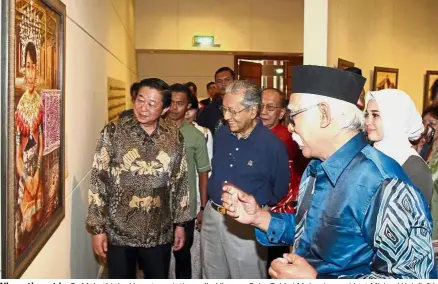  ??  ?? Where the art is: Dr Mahathir looking at a painting called Iban as Soka Gakkai Malaysia president Michael Kok (left), Ismail (right) and Emma (in white scarf) look on at SGM cultural centre.