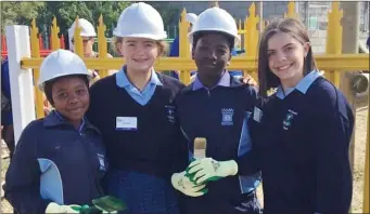  ??  ?? Leah and Hollie Corkery with two local girls during their trip to Cape Town. The girls were part of a 300-strong team of volunteers who took part in the mercy mission to the Wallaceden­e township.