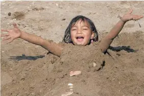 ?? Photo / Peter Meecham ?? Coco Hinekahuku­ra Turner, 3, buried in the sand at Mission Bay beach in Auckland yesterday.