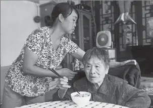  ?? WEI XIAOHAO / CHINA DAILY ?? Zhang Aiai, a domestic worker from Gansu province, takes care of a 95-year-old woman at her home in downtown Beijing on Monday.