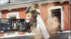  ?? TOM KELLY III — FOR DIGITAL FIRST MEDIA ?? Firefighte­rs tear out the roof eaves of 31 E. Fifth St. while responding to a fire there April 16.