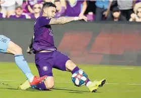  ??  ?? Orlando City’s Dom Dwyer kicks the ball and sets up a game-tying goal for teammate Tesho Akindele on Saturday. The Lions played NYCFC to a 2-2 draw.