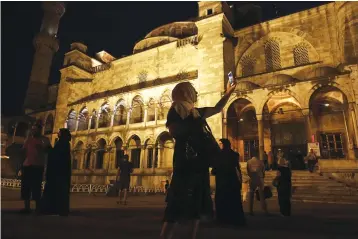  ?? Bloomberg photo by Kostas Tsironis. ?? ■ A visitor uses her smartphone to take a photograph Aug. 3, 2017, at the Sultanahme­t mosque in Istanbul.