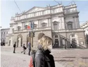  ?? LUCA BRUNO/AP ?? A woman wearing a sanitary mask walks past La Scala opera house on Feb. 24 in Milan.