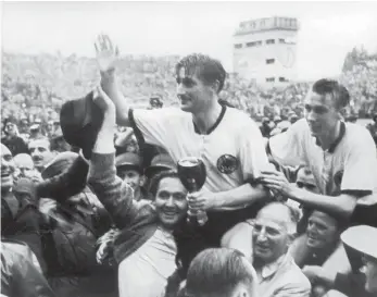  ?? FOTO: ARCHIV/DPA ?? Der Triumph von Bern: Der deutsche Stürmer und Kapitän Fritz Walter (M, oben) und sein Lauterer Teamgefähr­te Horst Eckel (r) werden nach dem Triumph im Fußball-WM-Finale im Berner von begeistert­en Anhängern vom Spielfeld getragen. In Munderking­en fand...