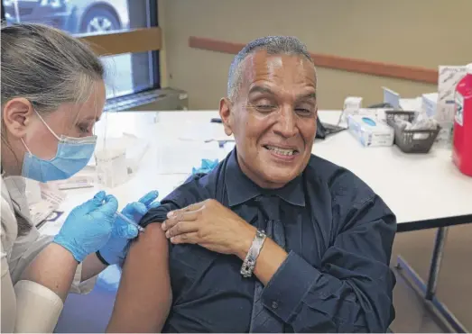  ?? SCOTT OLSON/GETTY IMAGES ?? Felipe Sanchez gets a COVID-19 booster shot from pharmacist Patricia Pernal at the Southwest Senior Center in September.