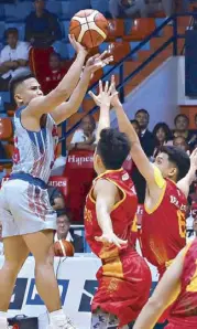  ?? KJ ROSALES ?? Arellano’s Levi dela Cruz pulls off a jumper against San Sebastian’s Arjan dela Cruz and Michael Calisaan.