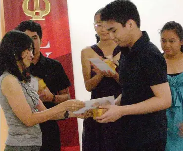  ??  ?? ALMA Joy Cristobal hands the cash prize to Lorenzo “Enzo” Medel.