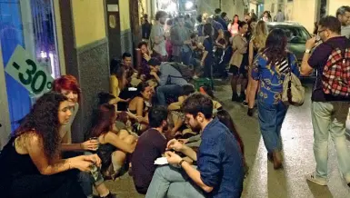  ??  ?? Gente seduta in strada e marciapied­i usati come tavoli, sabato sera, in Borgo La Croce