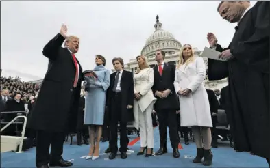  ?? The Associated Press ?? OATH OF OFFICE: President Donald Trump takes the oath of office from Chief Justice John Roberts, as his wife Melania holds the bible, and with his children Barron, Ivanka, Eric and Tiffany Friday on Capitol Hill in Washington.