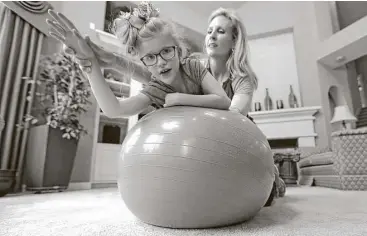  ?? David J. Phillip / Associated Press ?? Stacey English works on balance and core strength with her 7-year-old daughter, Addison, on Friday. Texas children with special needs have lost critical services since the state cut $350 million from Medicaid.