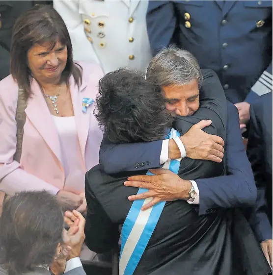  ?? ?? Milei y el ministro de Economía, Luis Caputo, se funden en un abrazo ante la mirada de Patricia Bullrich