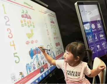  ??  ?? Starting young: Qian Yu enjoying the experience of learning with the interactiv­e whiteboard at the Sharp booth during the Star Education Fair 2018 at the Kuala Lumpur Convention Centre.