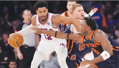  ?? Associated Press ?? Defense: Philadelph­ia 76ers forward Tobias Harris (12) is defended by New York Knicks forward OG Anunoby (8) during the second half of an NBA basketball game Tuesday at Madison Square Garden in New York.