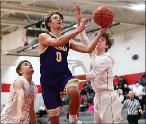  ?? DAVID C. TURBEN — FOR THE NEWS-HERALD ?? Berkshire’s Jay Wolfe (0) makes a late layup to extend the Badgers’ lead late in the fourth quarter past Cardinal’s Troy Damen (12) and Tony Soltis (11).