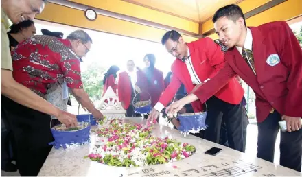  ?? ROBERTUS RISKY/JAWA POS ?? PENCIPTA INDONESIA RAYA: Pegiat sejarah dan mahasiswa menabur bunga di pusara makam W.R. Soepratman di kawasan Rangkah kemarin.