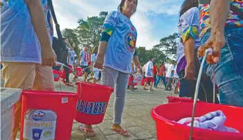  ?? SUNSTAR FOTO / AMPER CAMPAÑA ?? BUCKETS. Buckets are used to carry the food given to those attending the mass oathtaking of new members of PDP Laban-Cebu at the Plaza Independen­cia