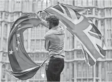  ?? JUSTIN TALLIS AFP/GETTY IMAGES ?? A man waves both a Eurpean Union flag and a U.K. flag at an anti-Brexit protest in central London on June 28, 2016.