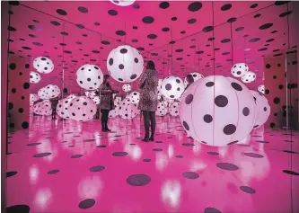  ?? BERNARD WEIL TORONTO STAR ?? A woman stands inside one of the installati­ons in the Infinity Room. The piece is part of of a display of the work of artist Yayoi Kusama, on display at the Art Gallery of Ontario, Toronto.