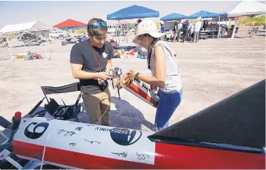  ?? ADOLPHE PIERRE-LOUIS/JOURNAL ?? University of Nevada, Las Vegas students Jacob Reed, left, and Mariana Rodriguez, put the finishing touches on their rocket, which is named Love Ship, before their team’s launch at the Spaceport America Cup competitio­n Thursday.