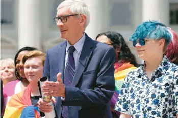  ?? MARK HOFFMAN/MILWAUKEE JOURNAL-SENTINEL ?? Wisconsin Gov. Tony Evers, left, attends a Rainbow Pride flag raising Wednesday in Madison. Evers, who is up for reelection, warned that if he loses, the GOP will push to ban books with LGBTQ themes.