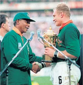  ??  ?? LEFT
South Africa President Nelson Mandela, left, presents the Webb Ellis Cup to Springboks captain Francois Pienaar in 1995.
FAR LEFT South Africa coach Rassie Erasmus lifts the World Cup trophy.